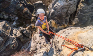 Happy young woman learning how to rappel in Santa Barbara County