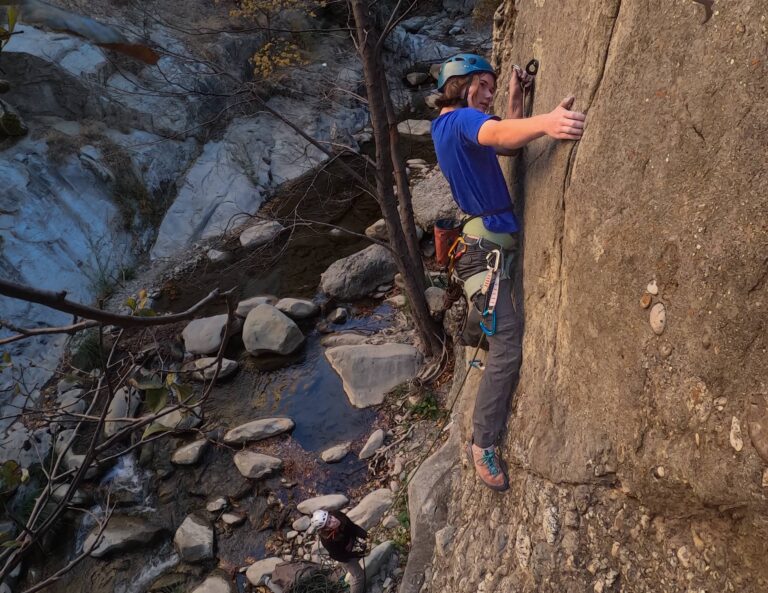 A young woman, a guest, learns to lead sport climbs with Santa Barbara Rock Climbing.