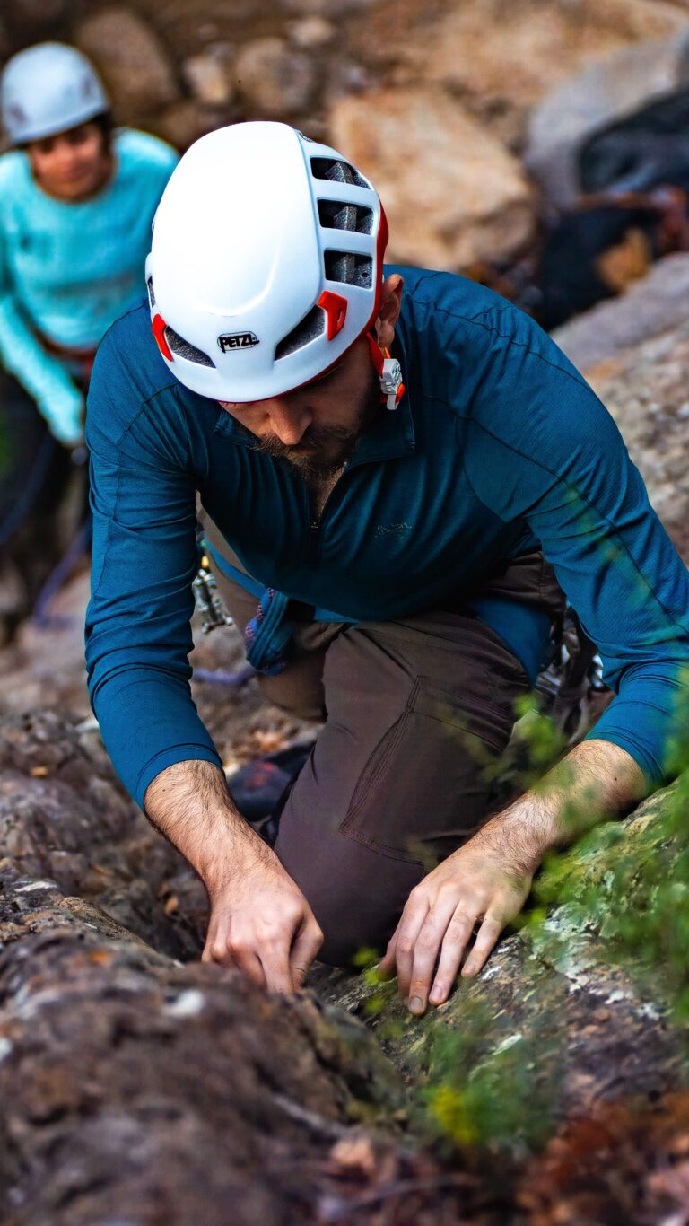 Male climber practicing gear placement during a single-pitch traditional climbing course in Santa Barbara, with focus on technique and hands-on instruction.