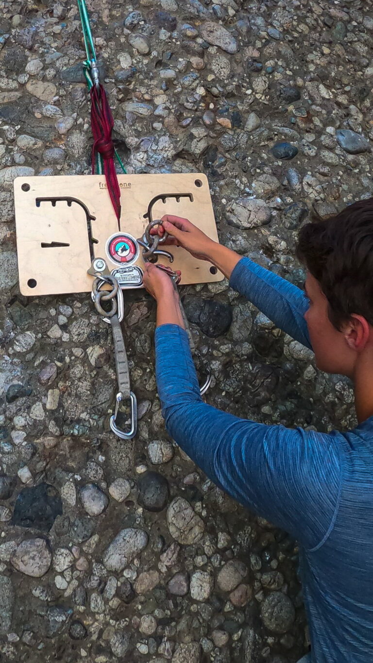Woman practicing anchor building during a single-pitch sport climbing course in Santa Barbara, learning safe and efficient top-rope anchor setup.